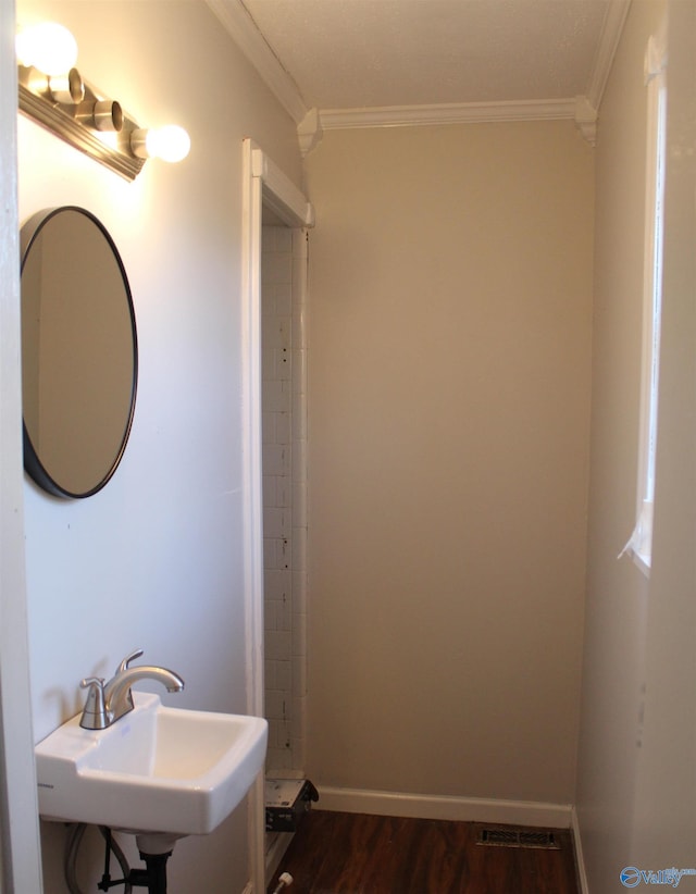 bathroom featuring sink, hardwood / wood-style floors, and crown molding