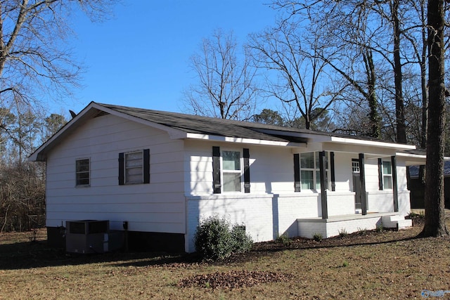 view of front of home with a porch, cooling unit, and a front lawn