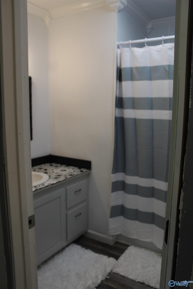 bathroom featuring hardwood / wood-style floors, crown molding, and vanity