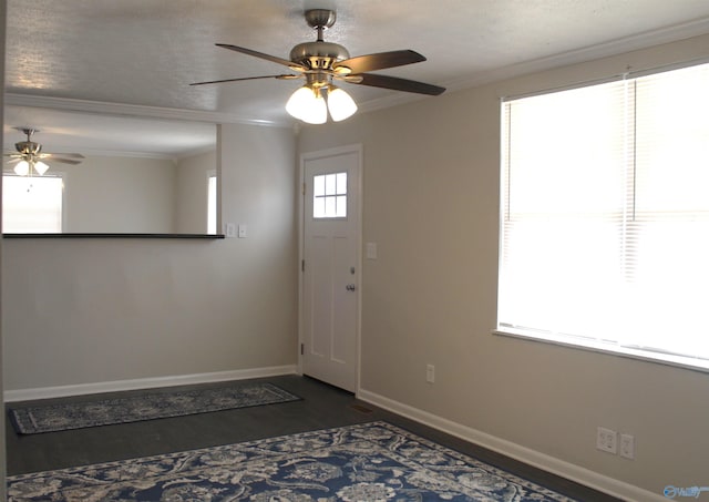 entrance foyer featuring a textured ceiling, ceiling fan, crown molding, and dark wood-type flooring