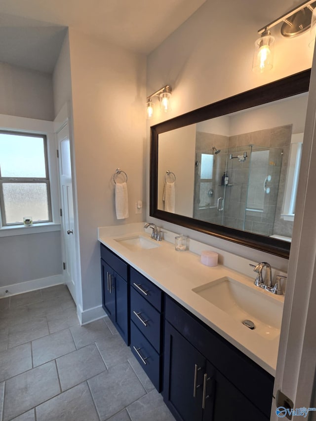 full bathroom featuring a shower stall, double vanity, baseboards, and a sink