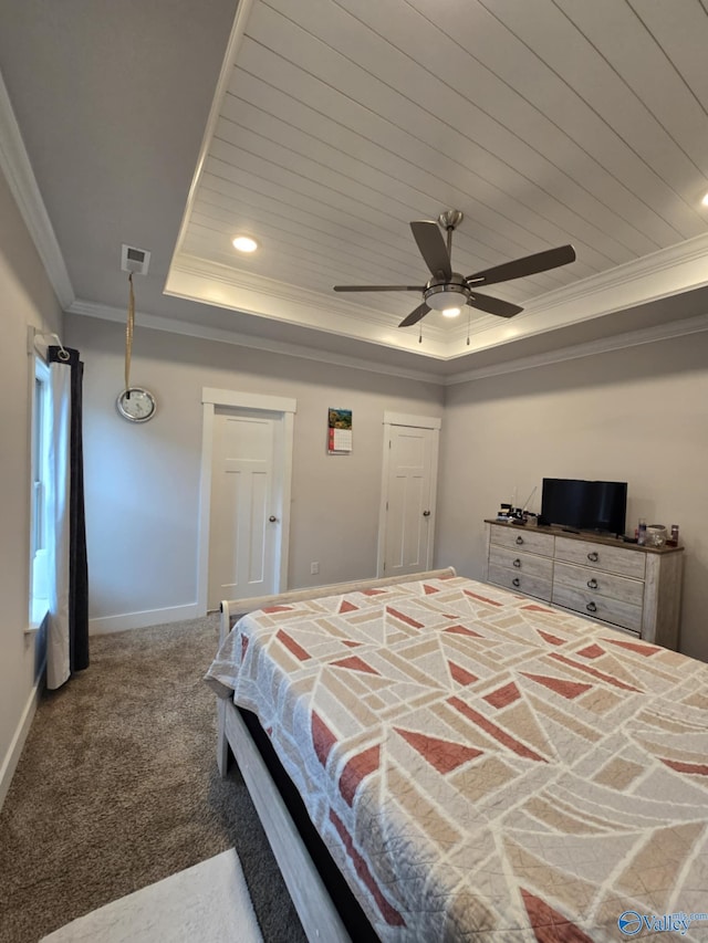 carpeted bedroom with visible vents, baseboards, wood ceiling, ornamental molding, and a raised ceiling