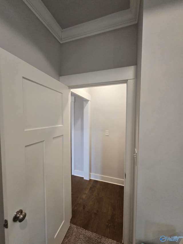 hallway with dark wood-style floors, baseboards, and ornamental molding