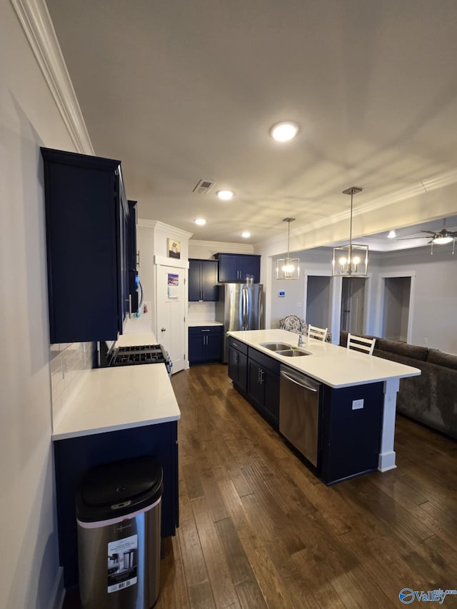 kitchen featuring light countertops, ornamental molding, dark wood-style floors, stainless steel appliances, and a sink