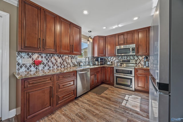 199 Ford Chapel Dr, Harvest, AL 35749 - kitchen featuring appliances with stainless steel finishes, a sink, light stone counters, decorative light fixtures, and dark wood-style floors