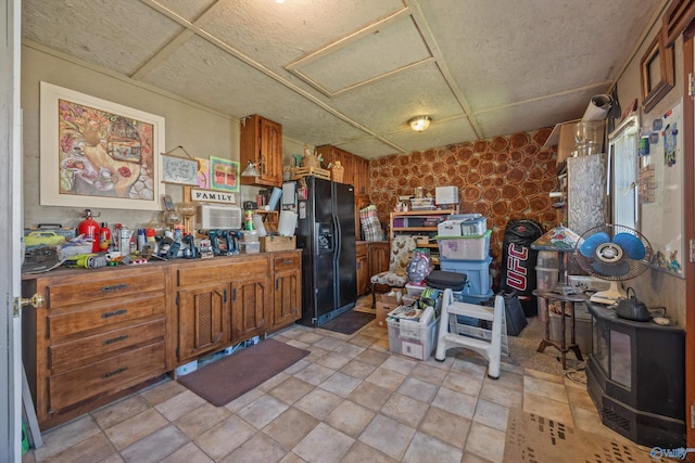 199 Ford Chapel Dr, Harvest, AL 35749 - kitchen featuring black refrigerator with ice dispenser, brown cabinetry, stone finish floors, and a wood stove