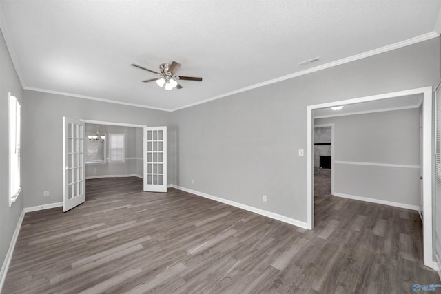 interior space featuring french doors, dark hardwood / wood-style flooring, ceiling fan with notable chandelier, and crown molding