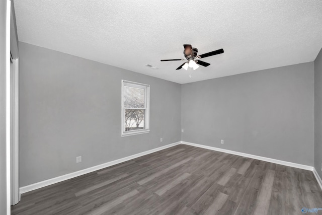 spare room with ceiling fan, a textured ceiling, and dark hardwood / wood-style flooring