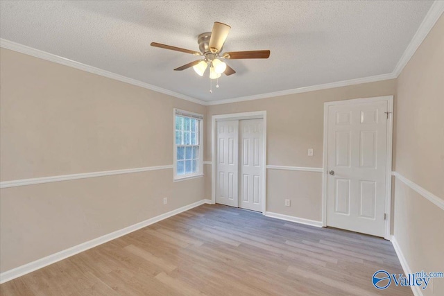 unfurnished bedroom with light hardwood / wood-style flooring, a textured ceiling, ornamental molding, a closet, and ceiling fan