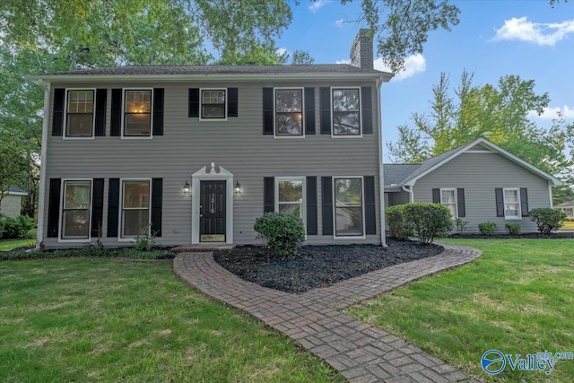 colonial home featuring a front lawn