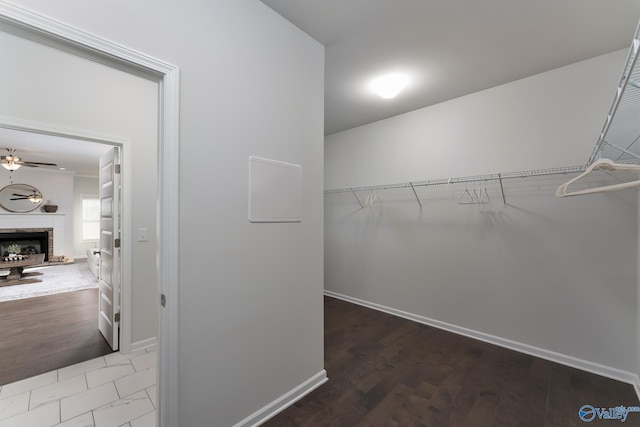 162 Saddle St, New Market, AL 35761 - walk in closet featuring a fireplace with raised hearth, wood finished floors, and ceiling fan