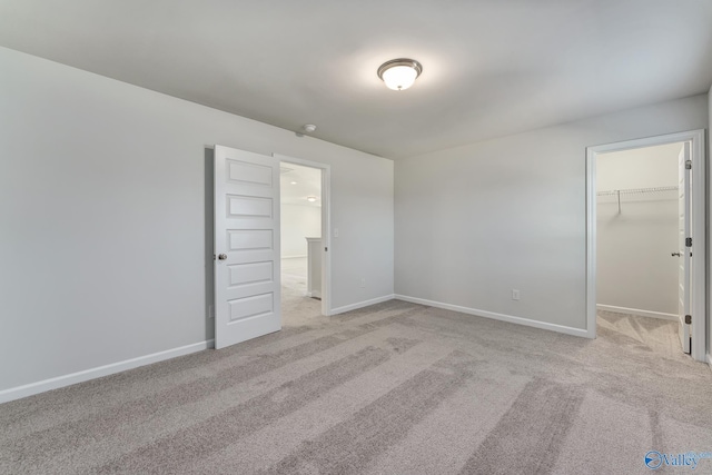 162 Saddle St, New Market, AL 35761 - unfurnished bedroom featuring baseboards, a walk in closet, and light colored carpet