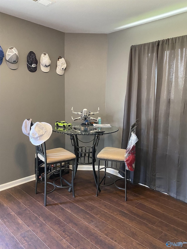 dining room featuring baseboards and hardwood / wood-style flooring