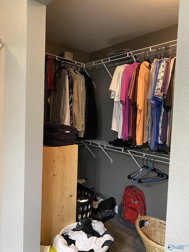 walk in closet with wood finished floors
