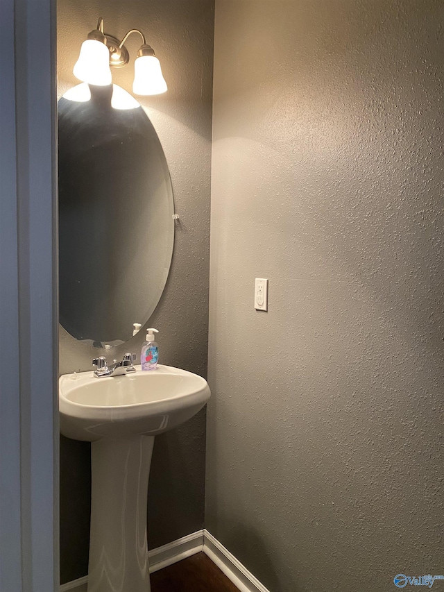 bathroom with a sink and baseboards
