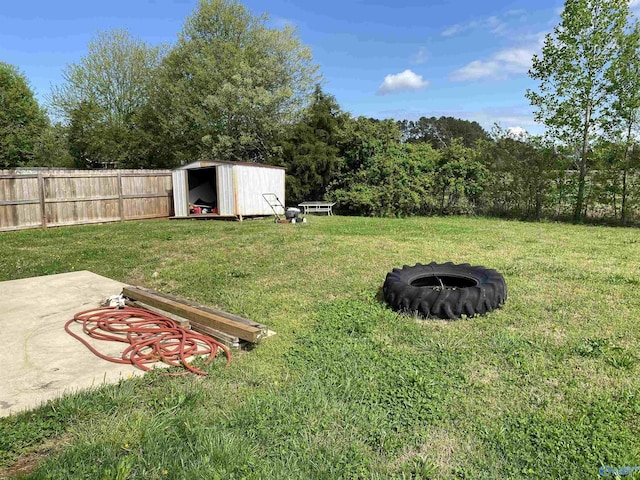 view of yard featuring an outbuilding, a patio, a storage unit, a fire pit, and fence