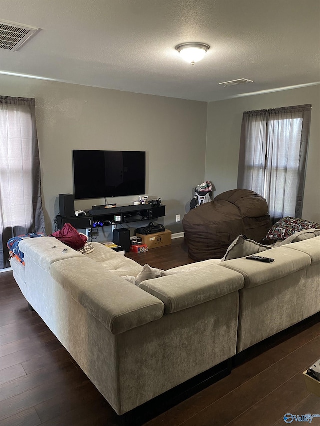 living room featuring dark wood-type flooring and visible vents