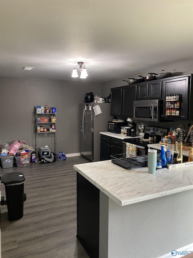 kitchen with light countertops, dark wood finished floors, dark cabinets, and stainless steel appliances