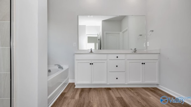 bathroom featuring hardwood / wood-style flooring, vanity, and a bath