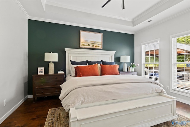 bedroom with ornamental molding, ceiling fan, dark hardwood / wood-style flooring, and a tray ceiling