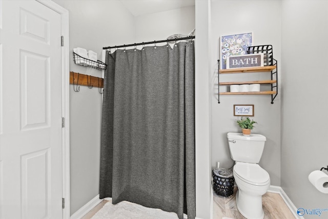 bathroom featuring walk in shower, toilet, and hardwood / wood-style flooring