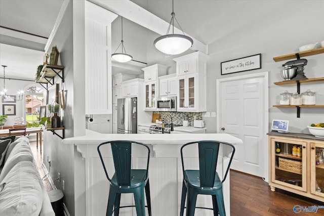 kitchen featuring pendant lighting, dark wood-type flooring, white cabinetry, stainless steel appliances, and kitchen peninsula