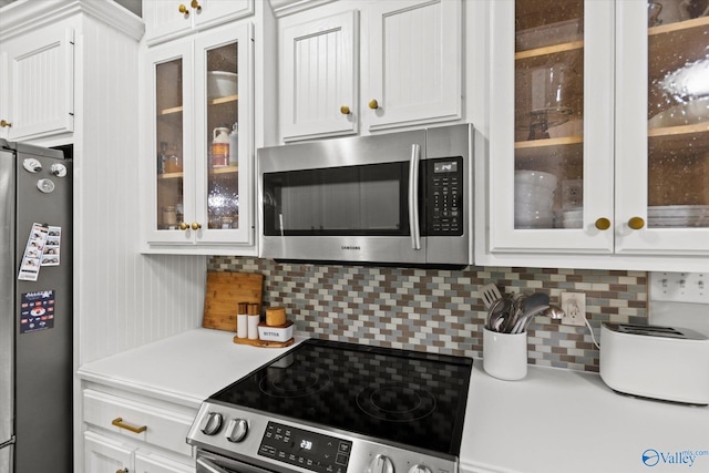 kitchen featuring white cabinetry, appliances with stainless steel finishes, and backsplash