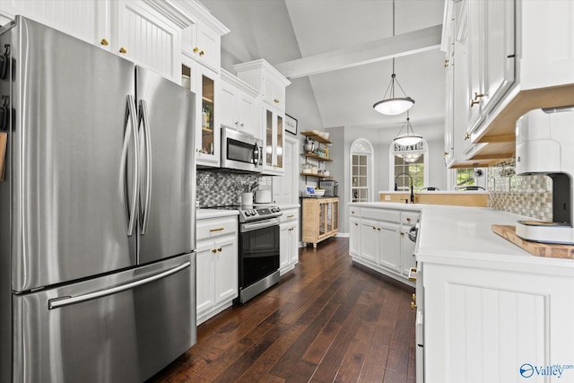 kitchen featuring white cabinetry, stainless steel appliances, dark hardwood / wood-style floors, lofted ceiling with beams, and decorative light fixtures