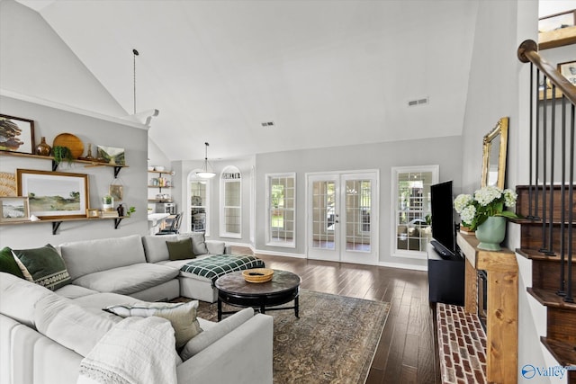 living room with dark hardwood / wood-style floors, high vaulted ceiling, and french doors