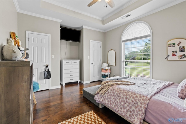 bedroom featuring a tray ceiling, ornamental molding, dark hardwood / wood-style floors, and ceiling fan