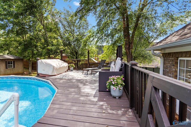 view of swimming pool with a wooden deck, area for grilling, and a shed