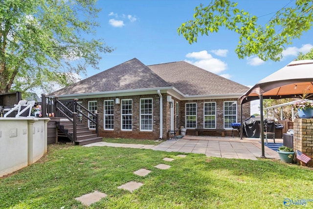 rear view of property featuring a gazebo, a patio area, and a lawn