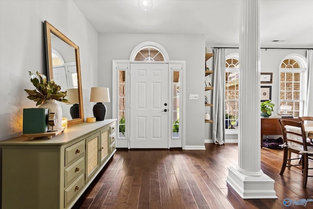 entrance foyer featuring dark hardwood / wood-style flooring and ornate columns