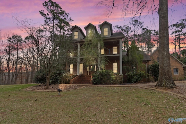 view of front of house featuring a front yard and a balcony