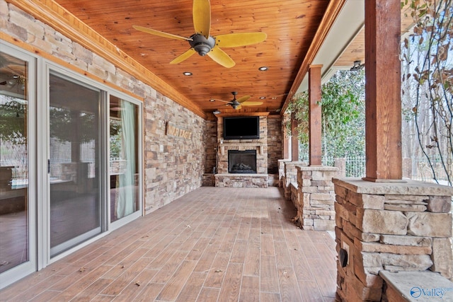 view of patio with an outdoor stone fireplace and ceiling fan