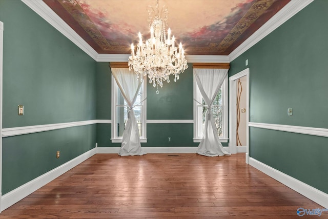 unfurnished dining area with ornamental molding, hardwood / wood-style flooring, baseboards, and an inviting chandelier