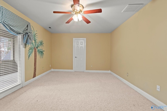 spare room featuring light carpet, baseboards, visible vents, and a ceiling fan