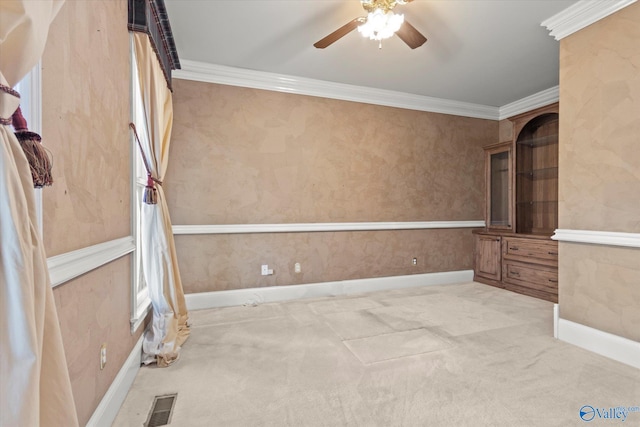 unfurnished room featuring baseboards, visible vents, ceiling fan, ornamental molding, and carpet floors