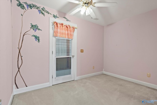 carpeted spare room with ceiling fan and baseboards