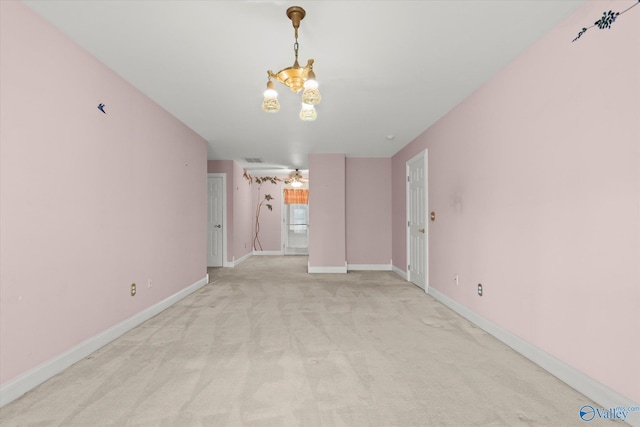 interior space with ceiling fan with notable chandelier, baseboards, and light colored carpet