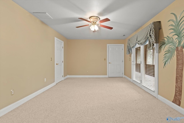 spare room featuring visible vents, baseboards, a ceiling fan, and light colored carpet