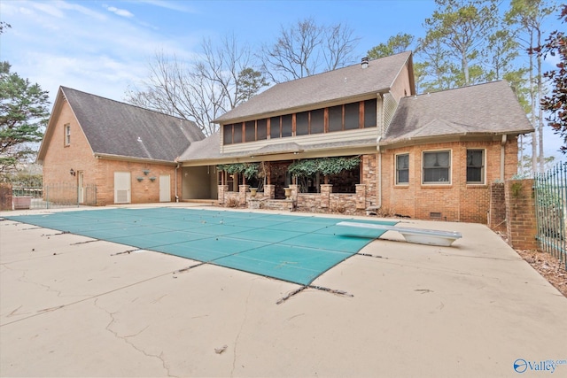 view of pool featuring a sunroom, a covered pool, fence, and a patio