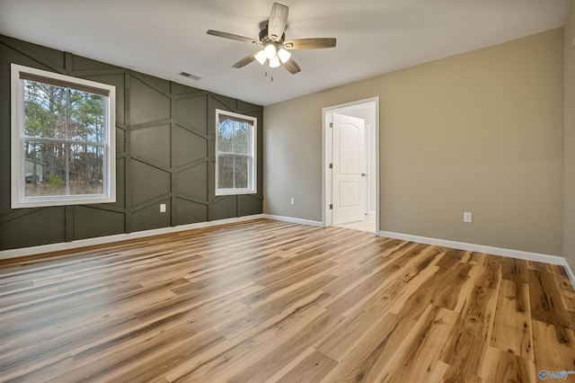 empty room with hardwood / wood-style flooring and ceiling fan