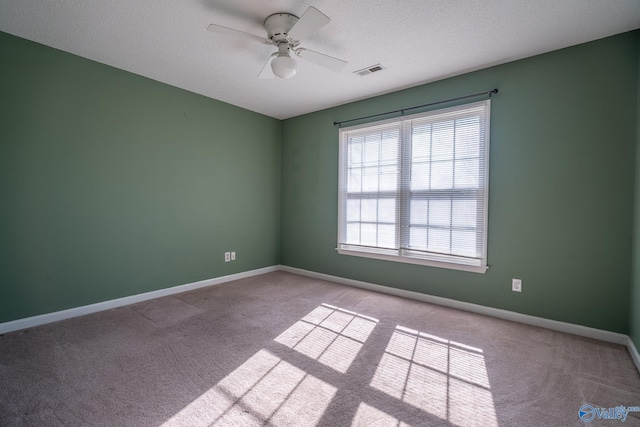 unfurnished room with visible vents, baseboards, a textured ceiling, and ceiling fan