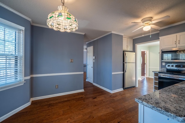 kitchen with dark wood finished floors, ornamental molding, appliances with stainless steel finishes, a textured ceiling, and white cabinetry