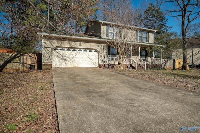 traditional-style home featuring a garage, covered porch, and driveway