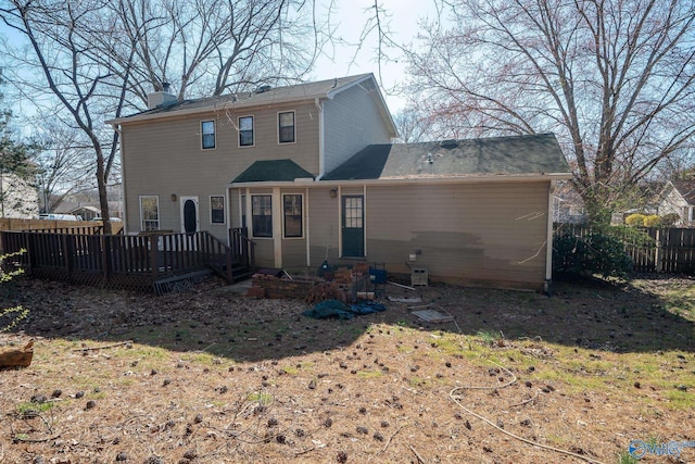 back of house with fence, a chimney, and a wooden deck