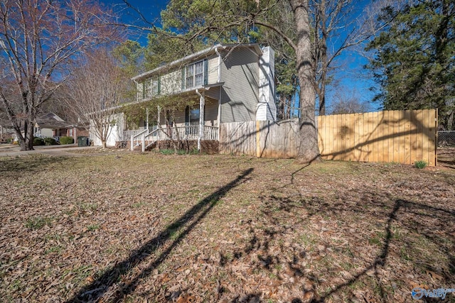 view of front facade featuring covered porch and fence