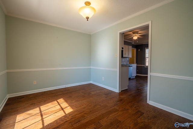 unfurnished room featuring baseboards, dark wood-style flooring, and crown molding