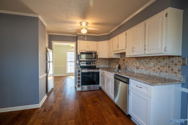 kitchen with a sink, stainless steel appliances, dark wood finished floors, and white cabinets